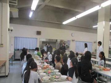 食堂でいただきますの前に食事係が感想をみんなに伝えている様子