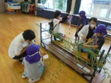 笹飾りを親子でつけている様子
