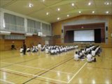 体育館で保健師の方のお話を聞く生徒の様子
