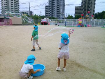 自分でつくった輪っかでシャボン玉をふくらませているところ