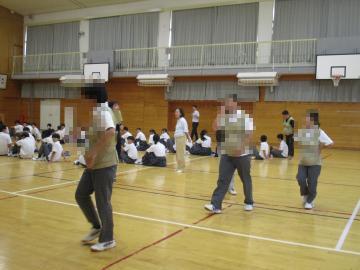 中学校の体育館で数名の生徒がお腹に重りをつけて、妊婦さん体験として歩いている様子