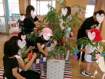 室内で園児たちが親子で笹飾りをしている様子