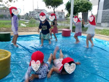 砂場プールで園児たちが泳いで遊んでいる様子