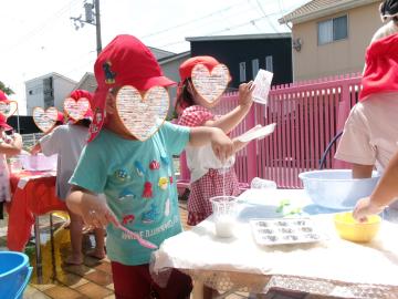 屋外で3歳児たちが魔法の粉で遊んでいる様子