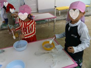 屋外で5歳児たちが泡クリームで遊んでいる様子