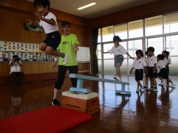 平均台で作られた傾斜を登り、一番高いところからマットへジャンプしている様子