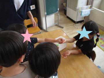 ジャガイモ屋さんごっこの最後にお金に見立てたリングを支払っている様子