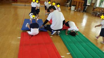 4歳児の運動遊びで、マットの上で前転をしている様子