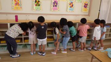 4歳児が大掃除で棚を拭いている様子