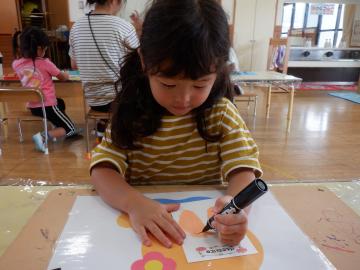ハガキに祖父母の顔を描く子供