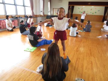 座った大人の膝の上に立ってポーズを決める子供