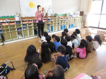 座って紙芝居を見る子供たち