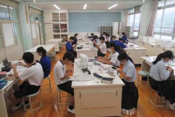 教室で、9年生が家庭科の授業で座布団を作っている様子