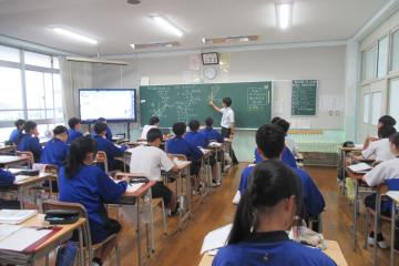 教室で、9年生が数学の授業で放物線と直線について学習している様子