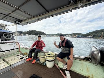 北脇水産の2名の生徒が漁船の上で記念撮影をしている