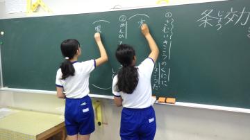 朝の学びタイムで漢字を黒板に書いている児童二人