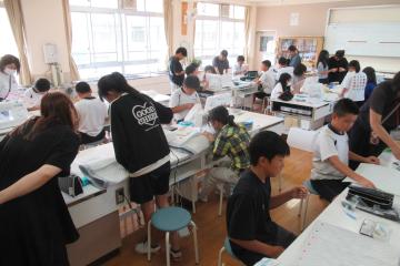 6年生家庭科裁縫の授業で保護者も一緒に取り組んでいる様子