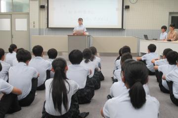 学級の代表が8年生全員の前で弁論をしている様子