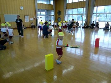 体育館でラケットにボールを乗せて運んでいる園児