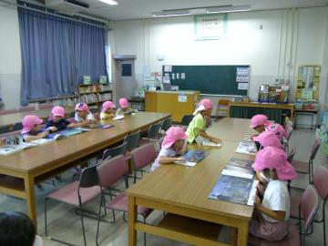 図書室の机に座って自分で選んだ本を開いてみている園児の様子