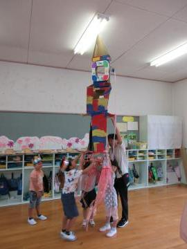 先生と子供たちで完成したロケットを持ち上げてとばして遊んでいる様子