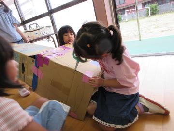 女の子が段ボールカッターを使って段ボールを切っている様子