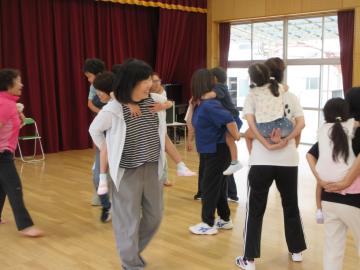 親が子供をおんぶし、歩いている様子