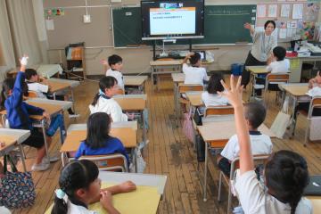講師の質問に手を上げて反応する3年生の様子