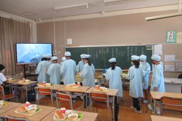 6年生給食係が手際よく配膳している様子