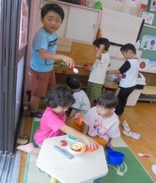 3歳児と5歳児が一緒にままごとをしている様子