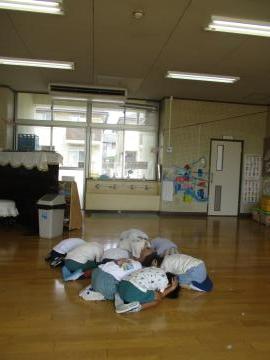 地震の避難訓練で、園児が頭を隠している様子。