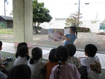 避難訓練で、地震が起きた時の身の守り方の紙芝居を見ている様子。