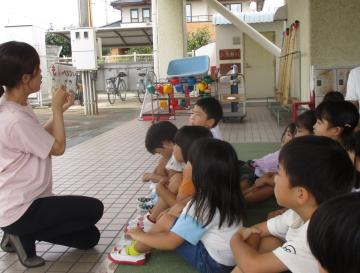 避難訓練で、園児が避難の約束について話を聞いている様子。