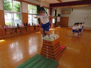 跳び箱の上をジャンプする子どもと後ろで待っている子供たち