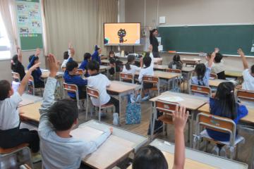 ALTの先生がイラストを示し、それを英語で表現できる2年生が手を上げている様子