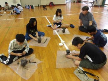 屋内で粘土を成形する児童たちの様子