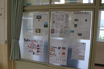 教室の窓ガラスに複数の学級新聞やポスターが掲示されている様子