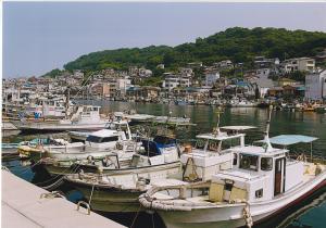 真浦港の家並みと舟の写真