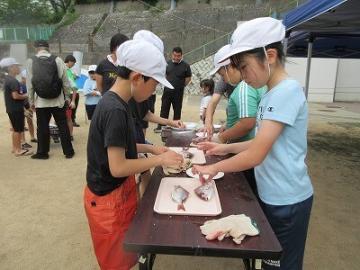 まな板の上の魚を調理作業をしている様子
