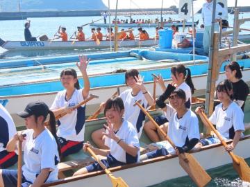 ボートに乗る子どもたちがオールを手に海上に並んでいる様子