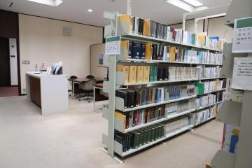 議会図書室の写真。受付、テーブル、本棚が並んでいる。